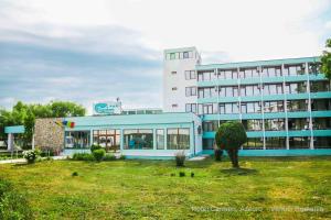a large building with a grass yard in front of it at Hotel Carmen in Venus