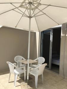 una mesa y sillas con una sombrilla en el patio en Summer Home, en Vlorë