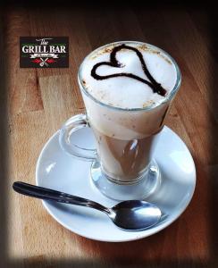 a cup of coffee on a plate with a spoon at Malaga City Breaks in M&aacute;laga