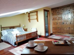 Un dormitorio con una cama y una mesa con platos. en Posada Paz en Hinojedo
