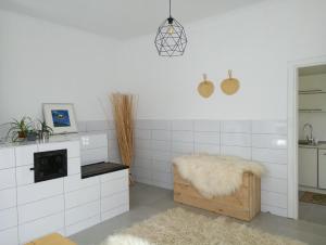a white room with a white tiled wall with a rug at Cosy House in Berkhomet-pe-Siret