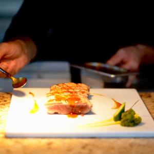 a person is eating food on a white plate at Gran Hotel Guadalpín Banus in Marbella