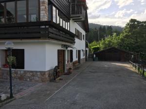 um edifício branco com uma varanda e uma entrada em La casa di Rosy em Enego