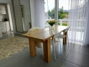 una mesa de madera con sillas y un jarrón de flores. en Cosy House, en Berkhomet-pe-Siret