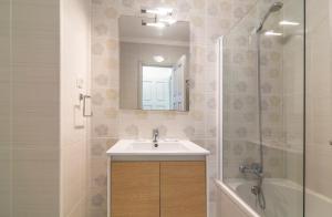 a bathroom with a sink and a mirror and a tub at The Old Village, Prestige and Solar by Village 4U in Vilamoura