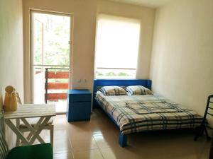 a bedroom with a bed and a table and a window at Villa Vachnadze in Shekvetili