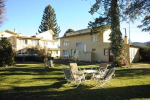 einen Tisch und Stühle im Hof eines Hauses in der Unterkunft Hostería Chimehuin in Junín de los Andes