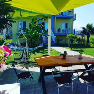 een houten tafel en stoelen met een speeltuin op de achtergrond bij Apartments Vista Mar in Orikum