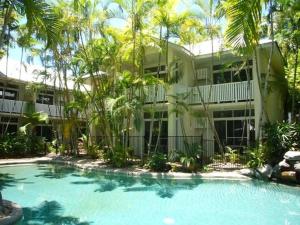 a building with a swimming pool in front of a building at Port Douglas Retreat in Port Douglas
