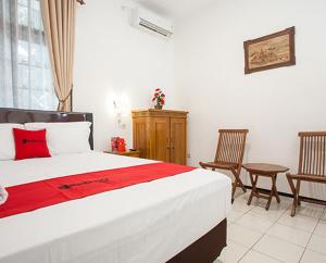 マランにあるRedDoorz near Sanan Malangのベッドルーム1室(ベッド1台、椅子2脚付)