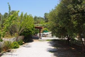 a dirt road with trees and a wooden shelter at El Kona in Mixórrouma