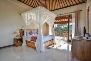 a bedroom with a bed with a canopy at Nata Ubud in Ubud