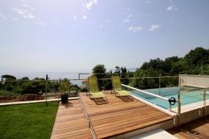 a wooden deck with chairs and a swimming pool at Apartment Pearl of Kvarner Lovran in Lovran