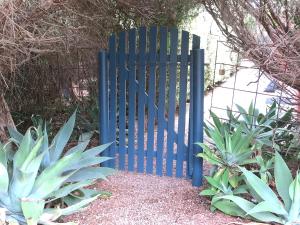 ein blaues Tor in einem Garten mit einigen Pflanzen in der Unterkunft A2@Port Willy in Port Willunga
