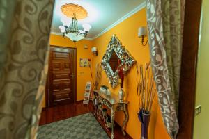 pasillo con paredes amarillas y espejo en Apartamento Lemavos, en Monforte de Lemos