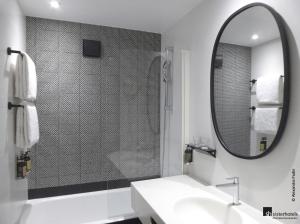 ein Bad mit einer Dusche, einem Waschbecken und einem Spiegel in der Unterkunft Tilsitt Etoile Paris in Paris
