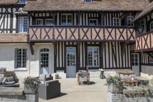 an old building with a blue door and a patio at Le manoir des chevaux dorés in Le Neubourg