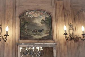 ein Gemälde von Pferden an einer Wand mit Lichtern in der Unterkunft Le manoir des chevaux dorés in Le Neubourg