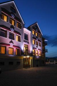 a large building with purple lights on the side of it at Hotel Milena in Milówka