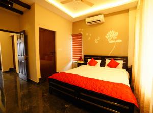 Metro Residency في كوتشي: غرفة نوم بسرير كبير ومخدات حمراء