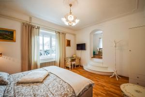 a bedroom with a bed and a window and a chandelier at Kavon Apartments in Ljubljana