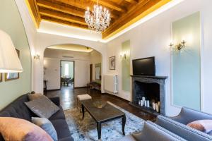 uma sala de estar com um sofá e uma lareira em Historic center Palace - Huge 4 bedrooms Santa Croce apartment apartment - AC in all rooms em Florença