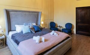 um quarto com uma cama grande e 2 cadeiras azuis em Historic center Palace - Huge 4 bedrooms Santa Croce apartment apartment - AC in all rooms em Florença