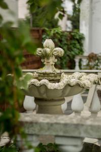 a stone fountain with a flower on top of it at Magic Garden Hostel in Kalisz