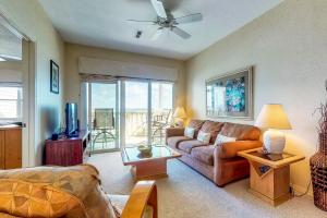 een woonkamer met een bank en een tv bij Baywatch in Pensacola Beach