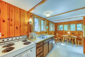 a kitchen with a stove and a sink and a table at Quintessential Maine Cottage in Ogunquit