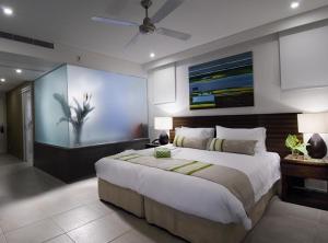a bedroom with a large bed and a painting on the wall at Pullman Port Douglas Sea Temple Resort and Spa in Port Douglas