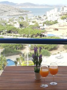 dos vasos de zumo de naranja sentados en un balcón en Apartment Monte Blanco, en La Manga del Mar Menor