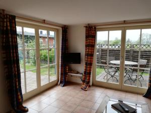 a living room with sliding glass doors and a balcony at Alter Schwede - Seedorf in Seedorf