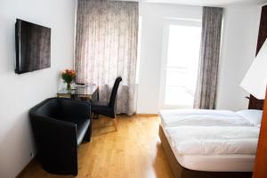 ein Schlafzimmer mit einem Bett, einem Tisch und einem Stuhl in der Unterkunft Hotel Stern in Düsseldorf