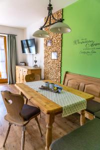 グライナウにあるAppartements Zugspitzdorf - Haus Wägerの緑の壁のダイニングルーム(木製テーブル付)