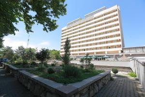 ein großes weißes Gebäude vor einem Gebäude in der Unterkunft Shodlik Palace in Taschkent