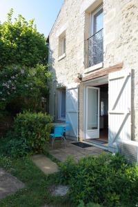 una casa con una silla azul junto a una puerta en Gîte La Loge des Fées en Latillé