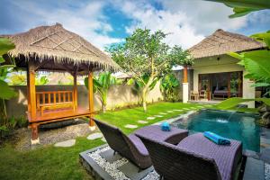 a backyard with a table and chairs and a swimming pool at Three Gold Luxury Private Villas in Ubud