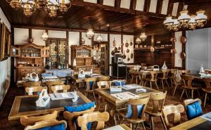 a restaurant with wooden tables and chairs in a room at Seehotel Baumgarten in Kehrsiten