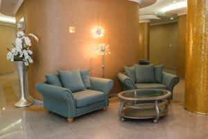 a lobby with two chairs and a table and flowers at Hotel International in Baile Felix