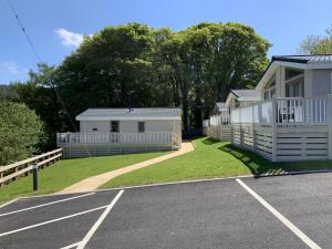 a house with a parking lot in front of it at Riverside Rothbury Superior Lodge in Rothbury