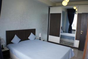 ママイアにあるKING 1のベッドルーム(白いベッド1台、大きな鏡付)