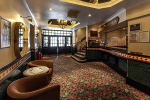 Habitación con bar con sillas y alfombra. en Scarisbrick Hotel, en Southport