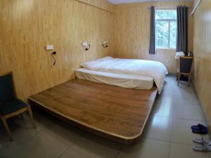 a bed with a wooden floor in a room at Dong Shan Gaga Hostel in Guangzhou