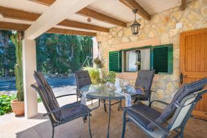 a patio with a glass table and chairs at Ca Na Sioneta in Campanet