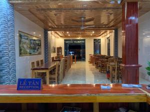 a dining room with wooden tables and chairs at Starlet Hotel Phong Nha in Phong Nha