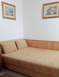 a bed in a room with two pictures on the wall at Apartament I in Rowy