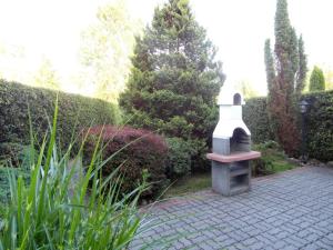 a garden with a stone lantern on a brick path at Apartament I in Rowy