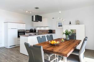 a kitchen and dining room with a wooden table and chairs at Terrassenwohnung "Usedom" - Oase am Haff in Garz-Usedom