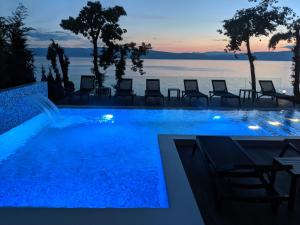 a swimming pool with a view of the water at night at Golden Sunset Apartments in Ohrid